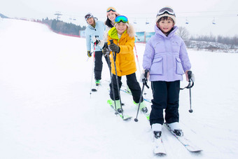 滑雪场内站一排滑雪的快乐家庭人写实图片