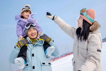 滑雪场上玩耍嬉戏的一家三口快乐氛围场景
