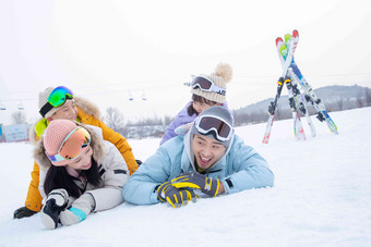 幸福快乐的一家四口趴在雪地上男孩高质量镜头
