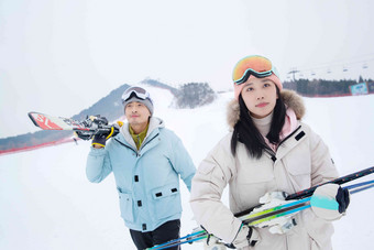 雪场上拿着滑雪板去滑雪的情侣双板氛围镜头