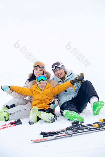 坐在雪地上快乐兴奋的一家三口冬天高质量照片