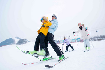 滑雪场内边滑雪边嬉戏的一家四口男孩高端照片