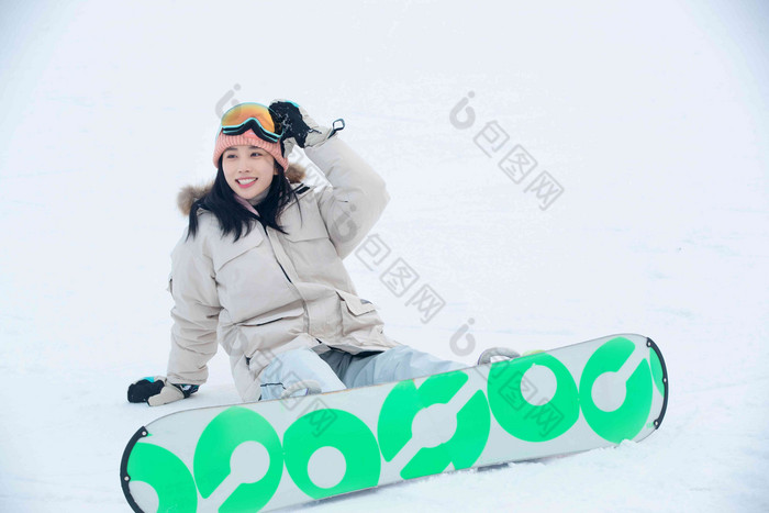 踩着单板坐在雪地上的青年女人运动高质量场景