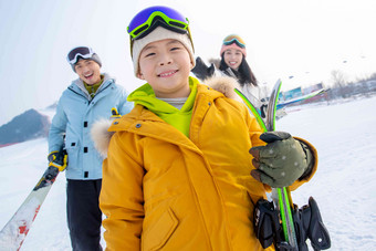 雪场上拿着滑雪板的一家三口中国人写实拍摄