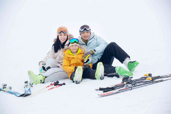 坐在雪地上幸福的一家三口