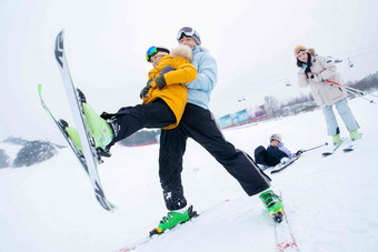 滑雪场内边滑雪边嬉戏的一家四口抱着高质量素材