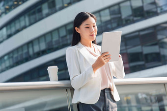 拿着平板电站在户外的商务女士女人照片