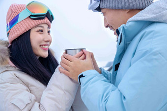 户外青年伴侣拿着杯子喝水冬天高清照片