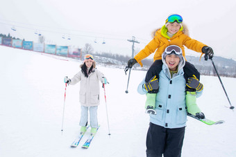 滑雪场内滑雪玩耍的三口之家儿子图片