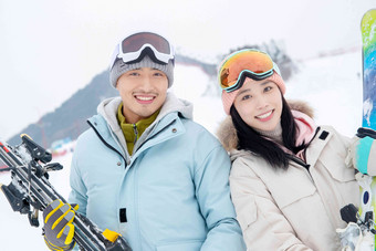 滑雪场上快乐的青年伴侣拿着雪具山氛围镜头
