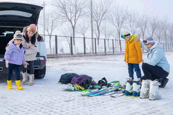 停车场内清点滑雪装备的一家四口儿童高清影相