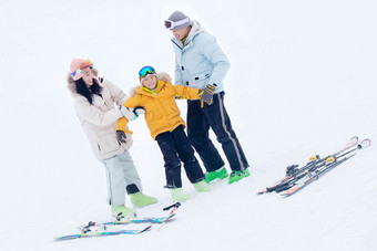 滑雪场上快乐玩耍的三口之家人高质量图片
