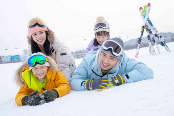 幸福快乐的一家四口趴在雪地上