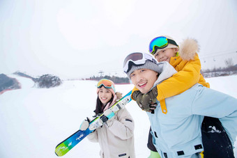 滑雪场上背着儿子的父亲和扛着滑雪板的母亲儿童高清镜头