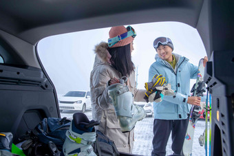 停车场内青年伴侣从汽车<strong>后备箱</strong>拿滑雪装备站着氛围场景