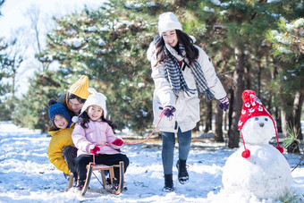 在雪地上玩雪橇的一家人青年女人高清素材