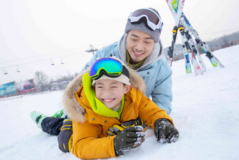 滑雪场内抱在一起打滚的快乐父子亲情写实镜头