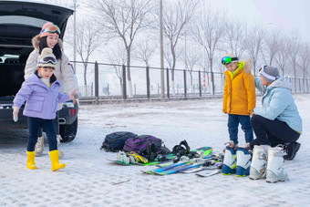 停车场内清点滑雪装备的一家四口