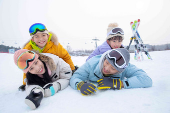 幸福快乐的一家四口趴在雪地上中国人高端素材