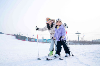 滑雪场上滑雪的快乐母女拿着高质量素材