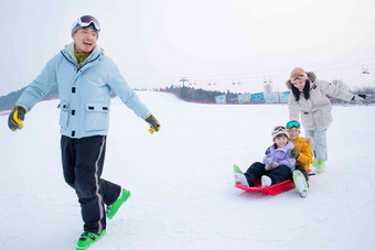 玩雪上滑板幸福的一家四口