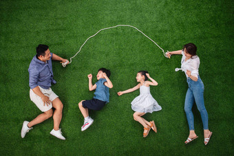 快乐的一家四口在草地上<strong>跳绳</strong>女孩高端摄影图