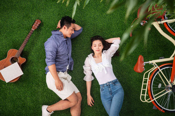幸福的青年伴侣躺在草地上小憩