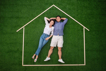 青年伴侣躺在草地上的房子轮廓里木板写实素材