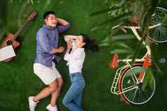 幸福的青年伴侣躺在草地上小憩无忧无虑拍摄