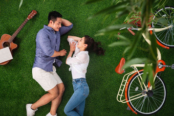 幸福的青年伴侣在草地上享受甜蜜时光