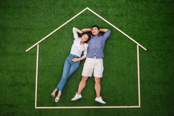 青年伴侣躺在草地上的房子轮廓里幻想氛围图片