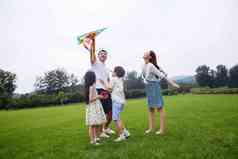 快乐的一家四口在草地上放风筝