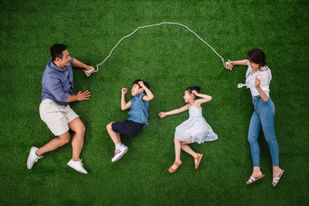 快乐的一家四口在草地上跳绳父亲氛围摄影