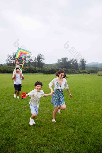 快乐的一家四口在草地上放风筝