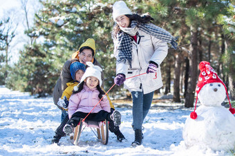 在雪地上玩雪橇的一家人幸福写实图片