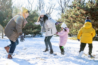 快乐的一家人在雪地里做游戏白昼高端摄影图