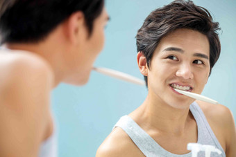 年轻男人对着镜子在刷牙青年男人高清图片