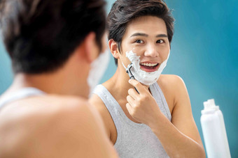 青年男人对着镜子刮胡子刮胡子图片