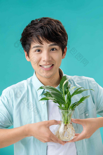 拿着绿色植物的青年男人