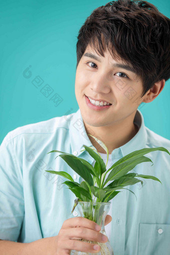 拿着绿色植物的青年男人