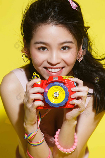 年轻女人拿着相机黄色<strong>背景</strong>高端场景