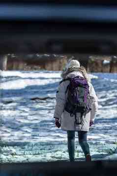 冬季年轻女人徒步旅行背影
