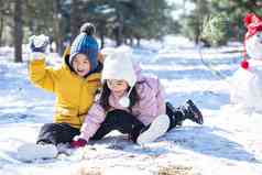 坐在雪地上玩耍的儿童和雪人