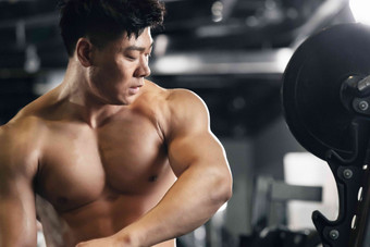 年轻男子在健身房展示肌肉