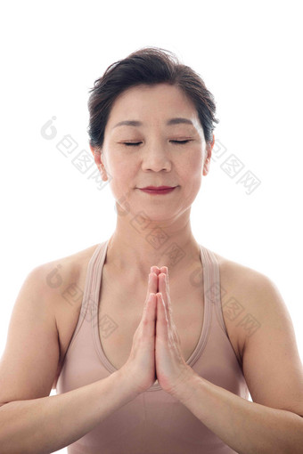 双手合十练瑜伽的中年女士特写优雅高端摄影图