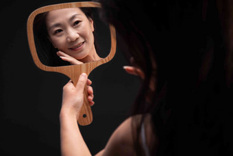拿着镜子照的中年女人成年人清晰素材