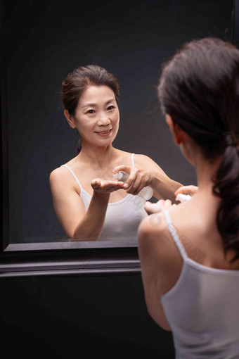优雅的中年女人对着镜子喷爽肤水优雅高质量摄影