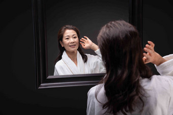 照镜子捋头发的优雅中年女人幸福高清图片