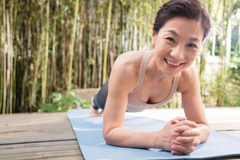 户外中老年女士趴着练瑜伽控制高清图片