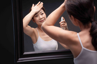 优雅的<strong>中年女人</strong>对着镜子涂抹爽肤水护肤清晰素材